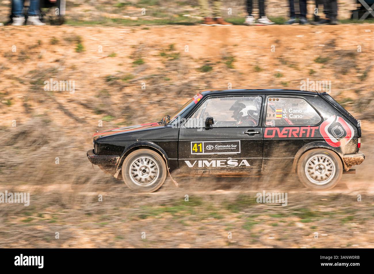 Madrid, Espagne ; 02-15-2025 : une Volkswagen Golf GTI classique se précipite sur une piste en terre battue, soulevant la poussière dans une course de rallye palpitante. La voiture vintage et ses Banque D'Images