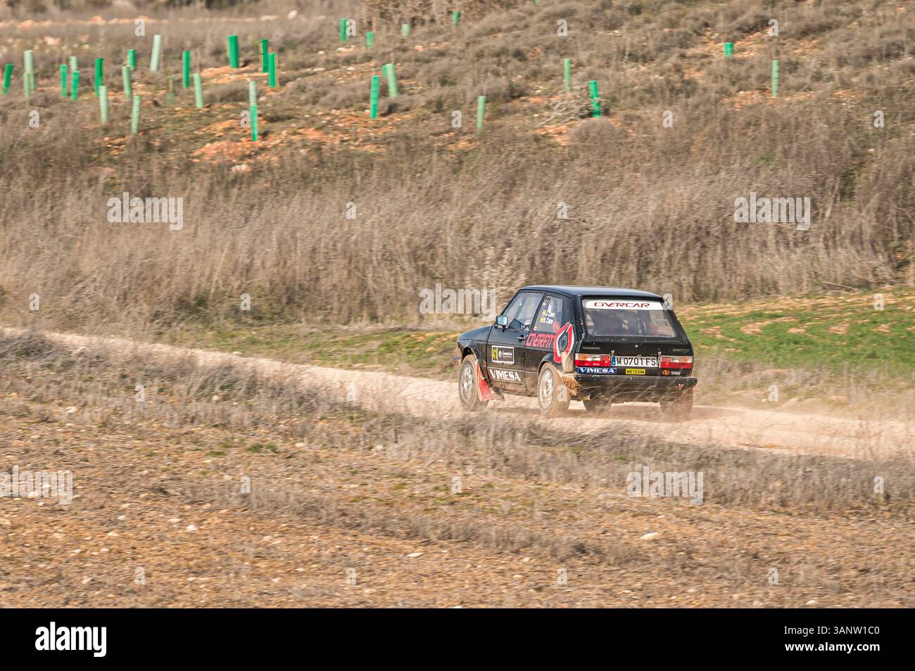 Madrid, Espagne ; 02-15-2025 : une Volkswagen Golf GTI classique accélère sur un circuit poussiéreux, laissant derrière elle une traînée de terre. Le coureur compact incardi Banque D'Images