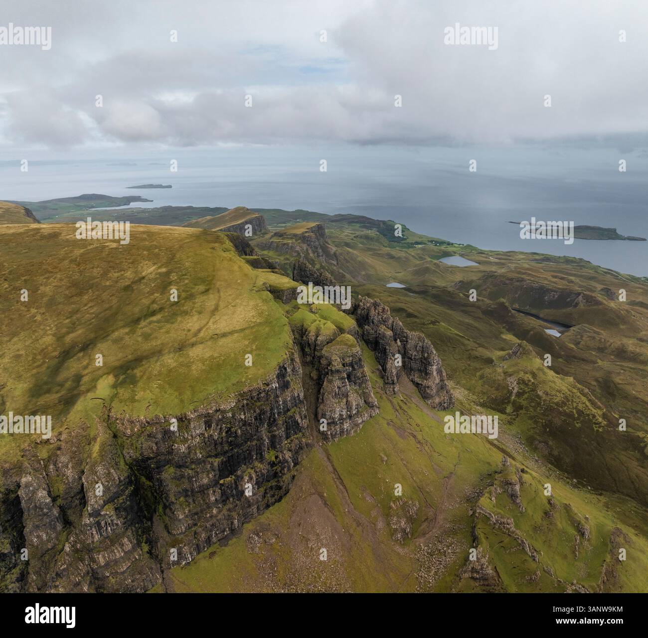 Vue aérienne de la majestueuse montagne Quiraing avec ses falaises escarpées et sa mer sereine, Portree, Écosse. Banque D'Images