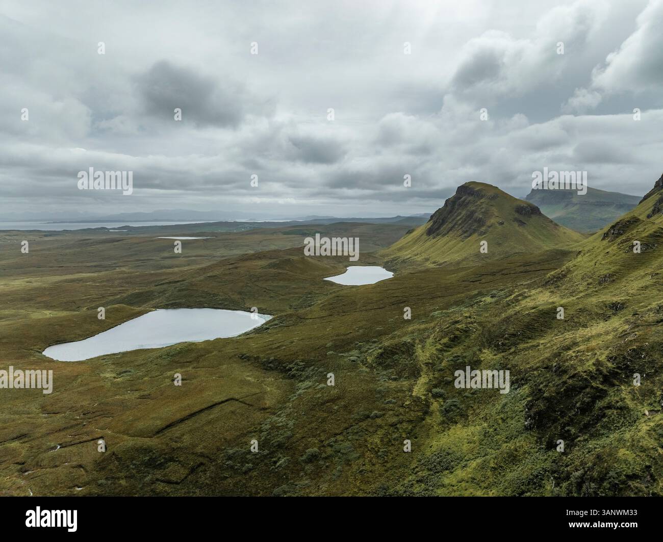 Vue aérienne de la montagne Quiraing avec un loch serein et des vallées spectaculaires, Portree, Écosse. Banque D'Images