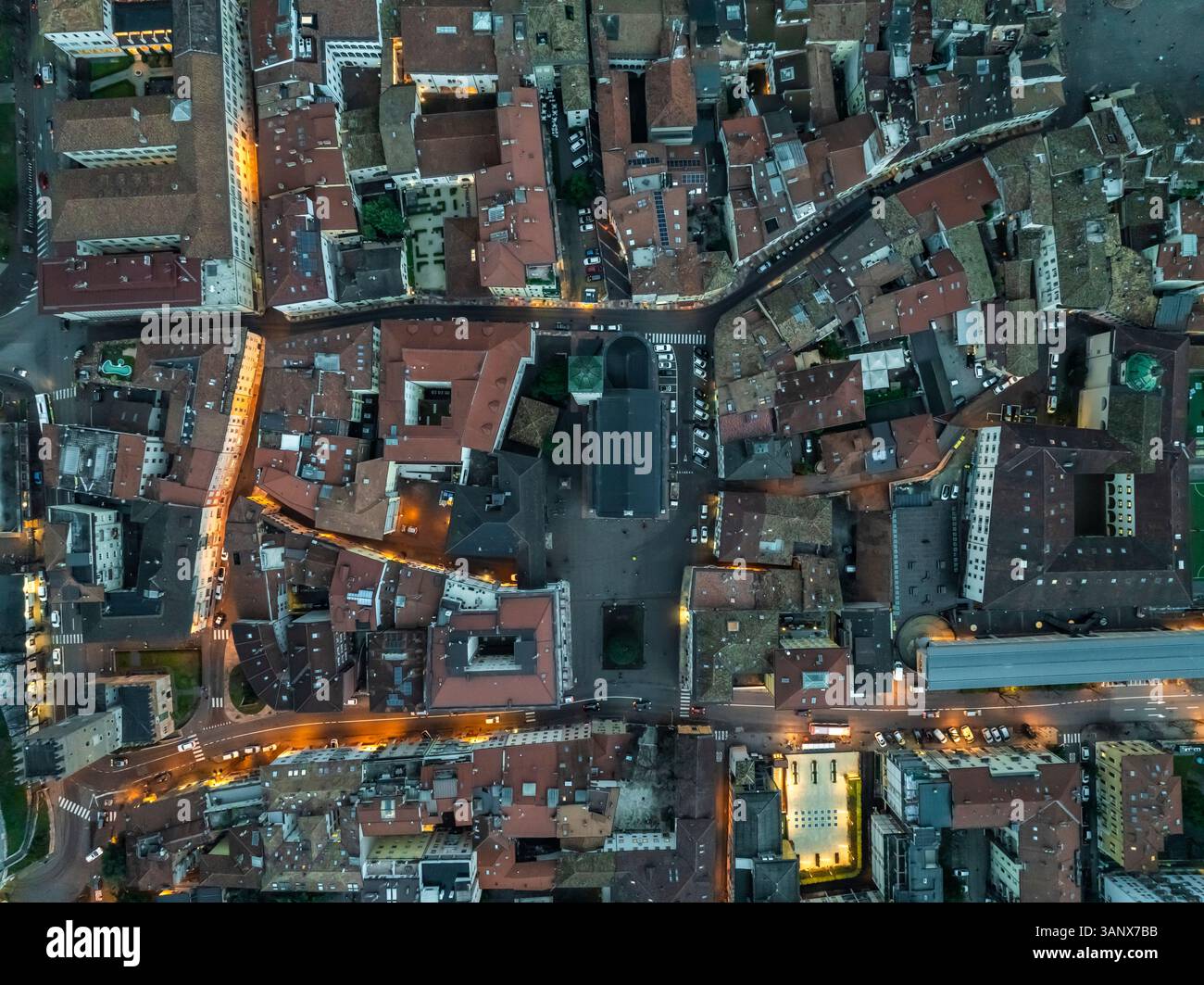 Vue aérienne de la belle trente, Trentin au crépuscule, avec des rues illuminées et des toits, mettant en valeur les monuments historiques et l'architecture italienne traditionnelle de la ville, Italie. Banque D'Images