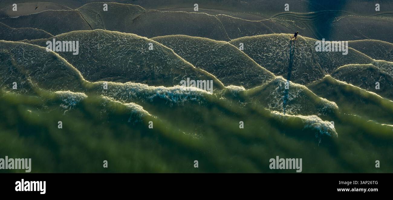 Vue aérienne de la plage sereine avec marcheur et vagues apaisantes, Pass-A-grille, Floride, États-Unis. Banque D'Images