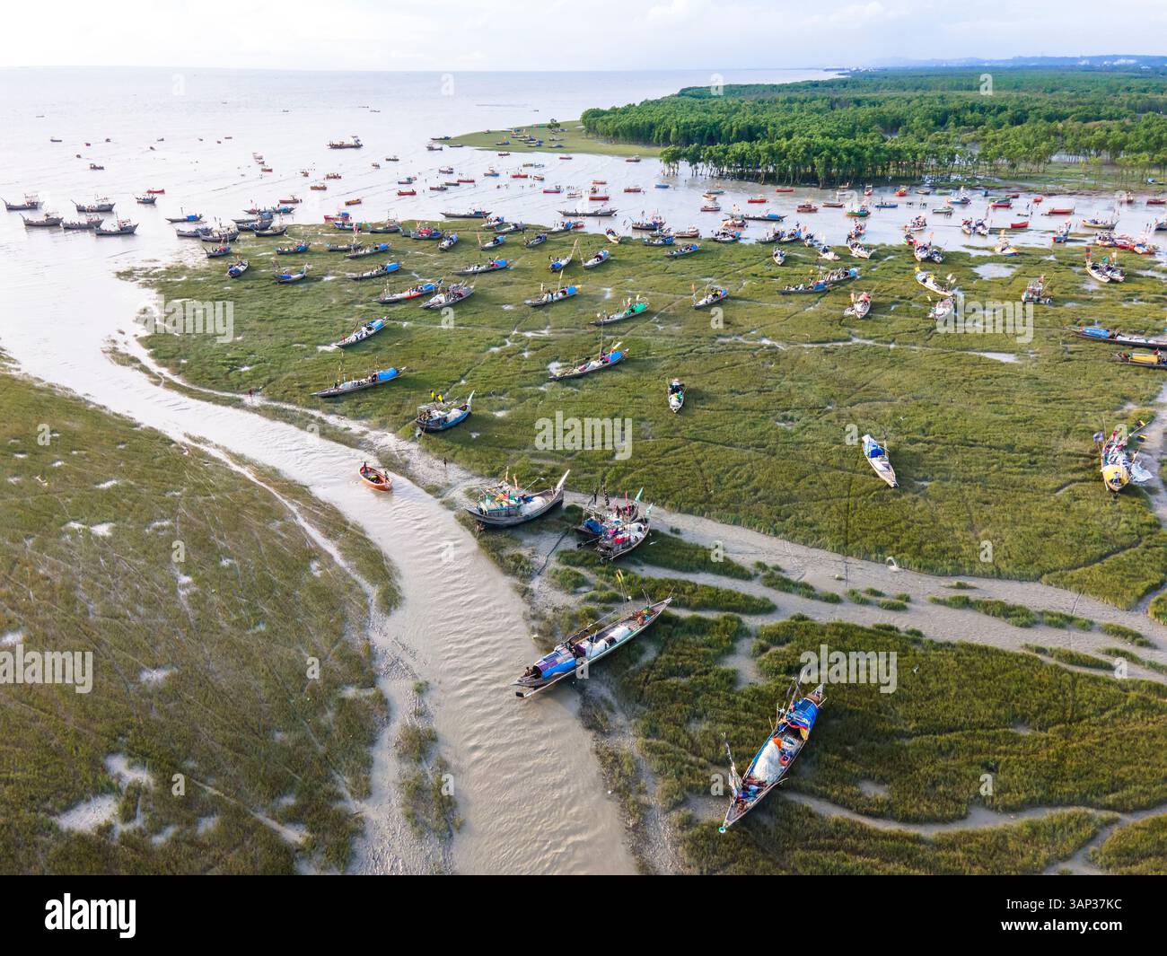 Vue aérienne de pêcheurs avec des bateaux amarrés réparant des filets et se reposant la nuit dans la baie du Bengale, Chittagong, Chittagong, Bangladesh. Banque D'Images
