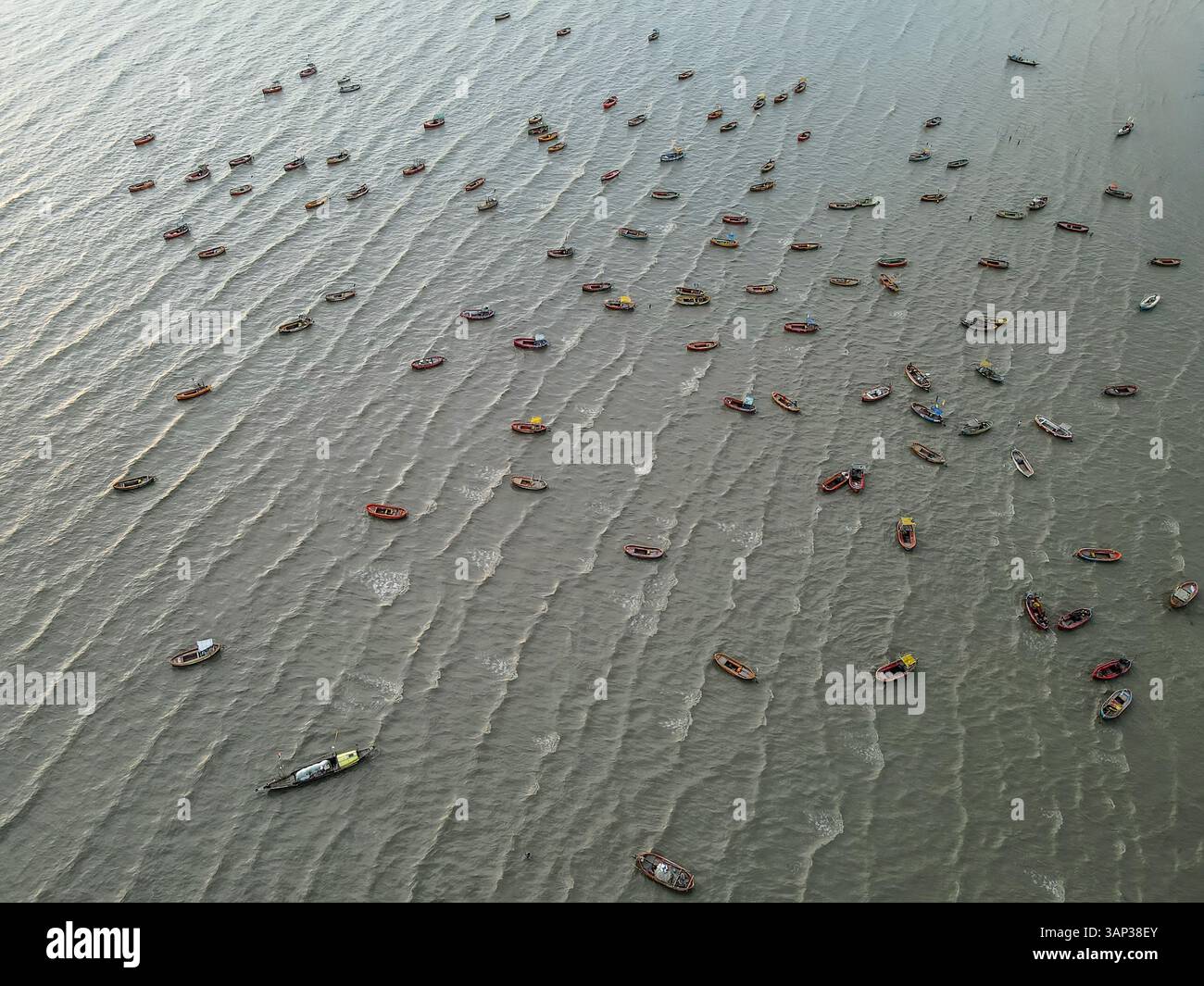 Vue aérienne de pêcheurs réparant des filets et des bateaux amarrés la nuit dans la baie du Bengale, Chittagong, Bangladesh. Banque D'Images