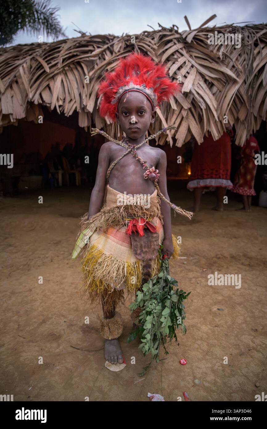 Portrait d'un garçon devant un temple, vêtu d'un costume rituel fait de peaux d'animaux et de plumes, un matin après une cérémonie toute la nuit. Banque D'Images