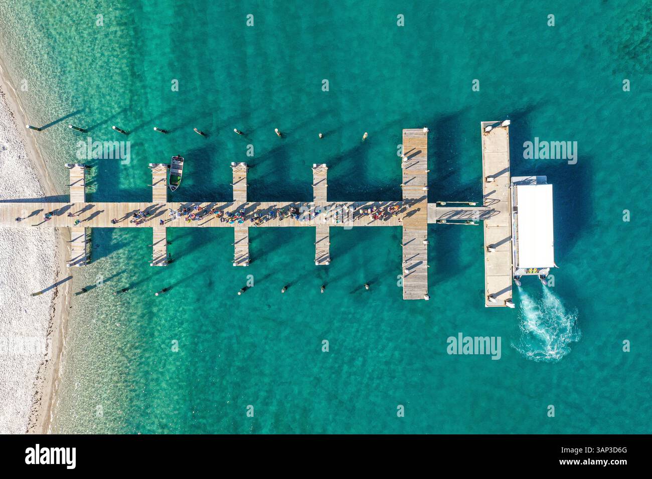 Vue aérienne d'un quai de navigation entouré d'eaux bleues claires, avec des gens attendant de monter sur le bateau sur Peanut Island Park près de Riviera Beach, Floride, États-Unis. Banque D'Images
