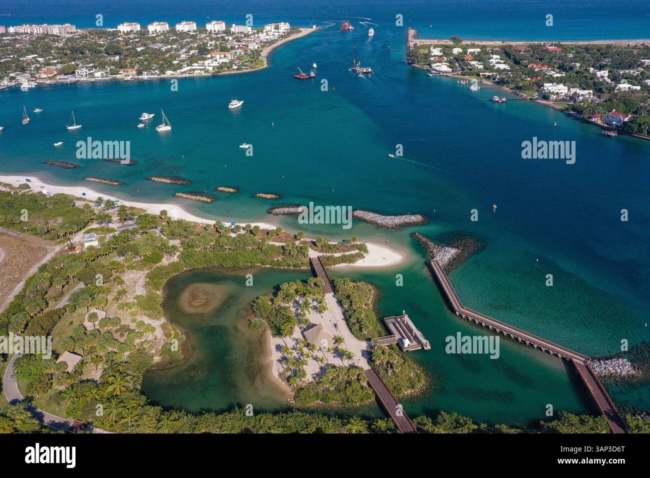 Vue aérienne du parc Peanut Island entouré d'eaux bleues claires avec des bateaux ancrés et passant par le canal près de Riviera Beach, Floride, États-Unis. Banque D'Images