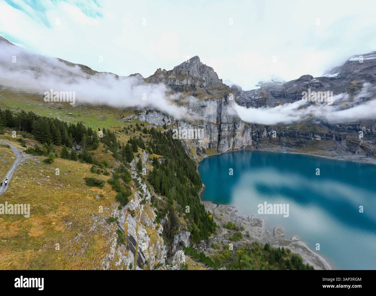 Vue aérienne du lac serein Oeschinen avec des montagnes enneigées et des reflets, Kandersteg, Suisse. Banque D'Images