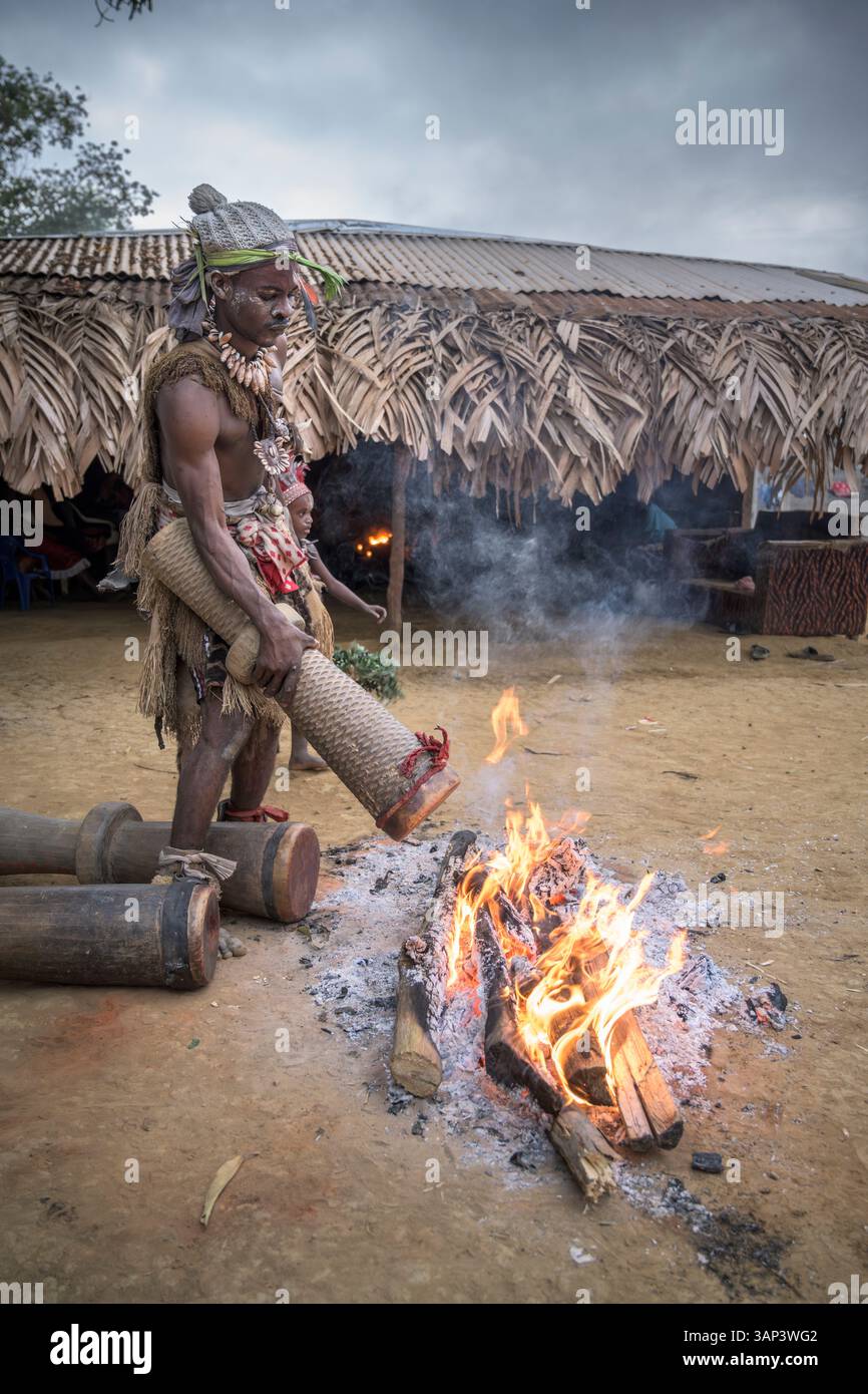 Les participants à une cérémonie Bwiti réchauffent des tambours près du feu pour améliorer leur son. Banque D'Images