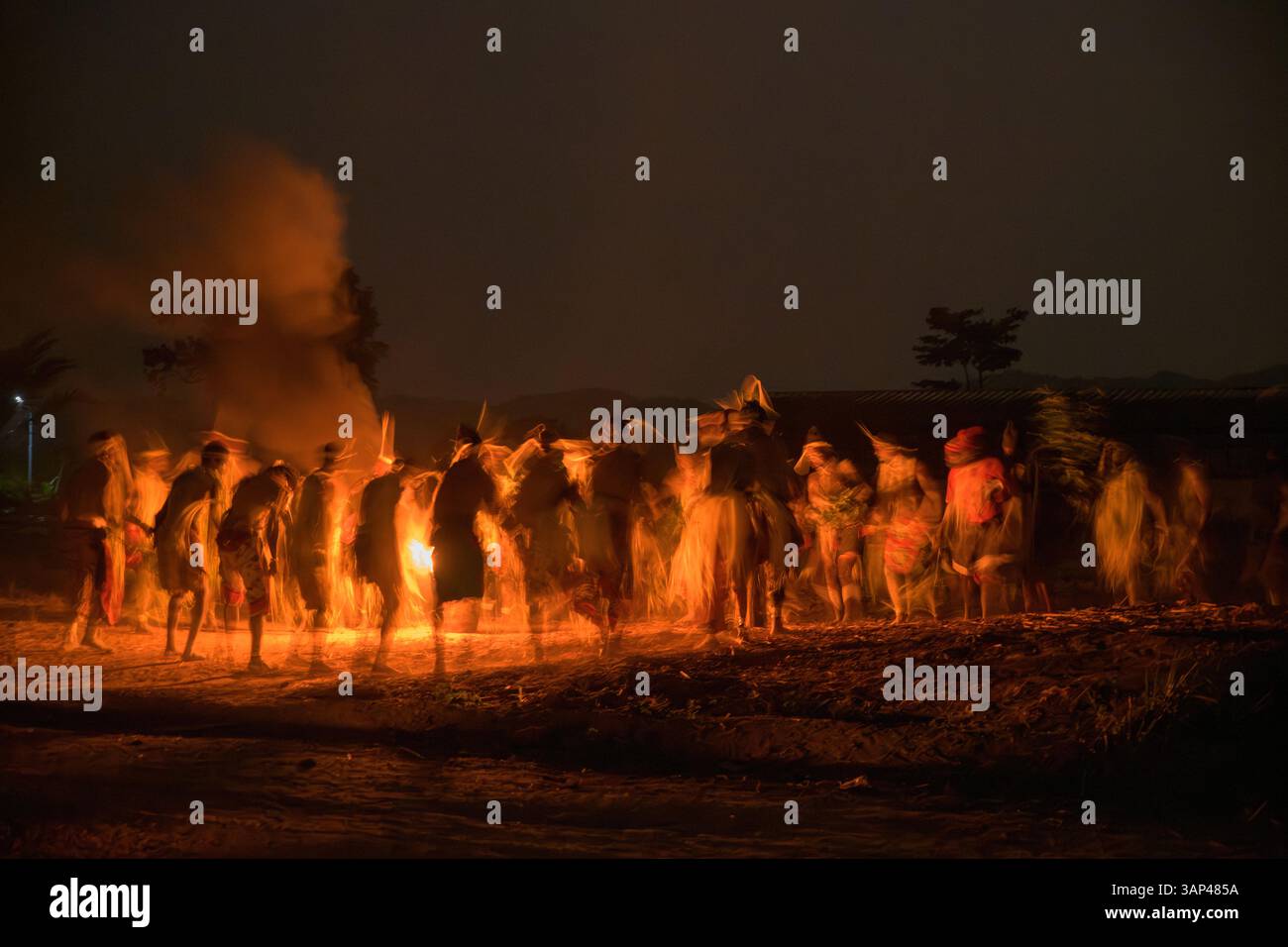 Groupe de personnes dansant autour du feu sacré pendant une cérémonie de Bwiti la nuit. Banque D'Images