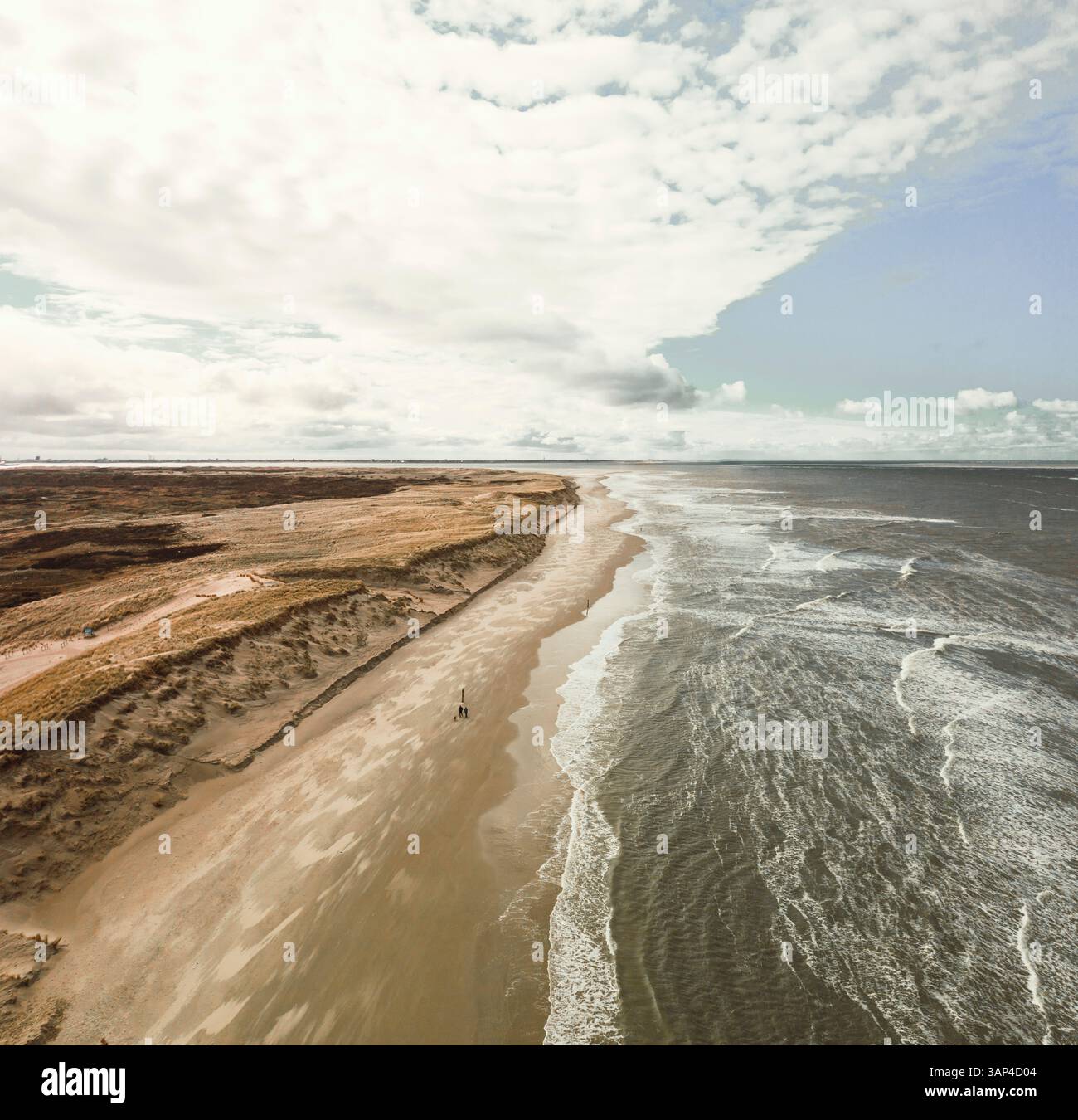 Vue aérienne de la côte avec des vagues pendant une journée nuageuse face à la mer du Nord dans la région de Hollande du Nord, pays-Bas. Banque D'Images