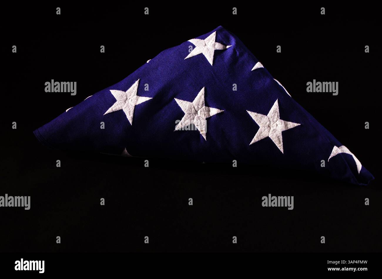 Drapeau américain plié affiché sur un fond sombre, symbolisant le service militaire, le sacrifice et le souvenir. Couramment présenté pendant milita Banque D'Images Drapeau américain plié affiché sur un fond sombre, symbolisant le service militaire, le sacrifice et le souvenir. Couramment présenté pendant milita Banque D'Images