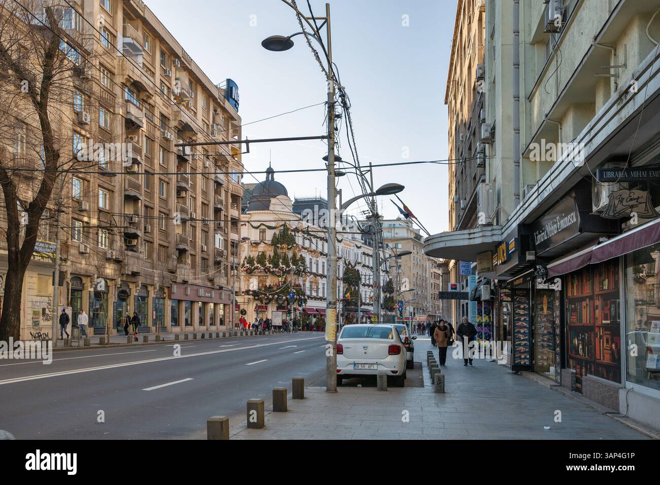 Bucarest, Roumanie - 01 janvier 2025 : les gens marchent le long du boulevard Regina Elisabeta dans le centre-ville. Grand Hôtel du Boulevard Corinthia en arrière-plan. Banque D'Images