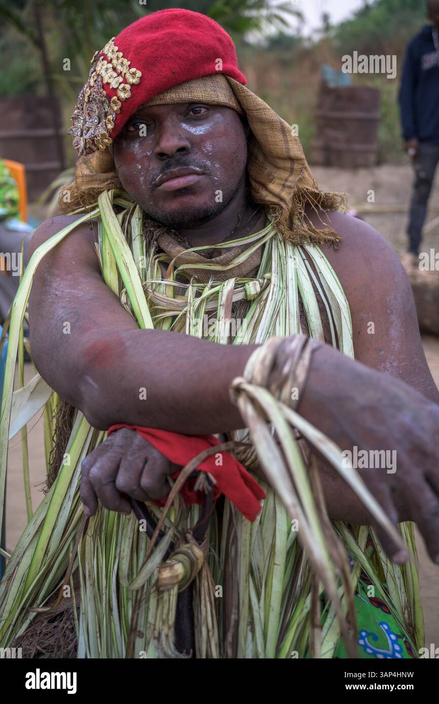 Portrait d'un homme vêtu d'un costume rituel fait de feuilles de palmier séchées, après une cérémonie de Bwiti toute la nuit. Banque D'Images