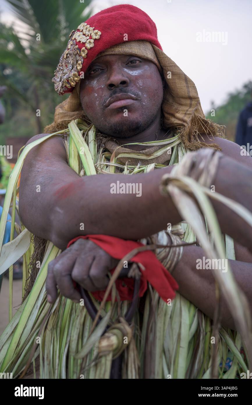 Portrait d'un homme vêtu d'un costume rituel fait de feuilles de palmier séchées, après une cérémonie de Bwiti toute la nuit. Banque D'Images