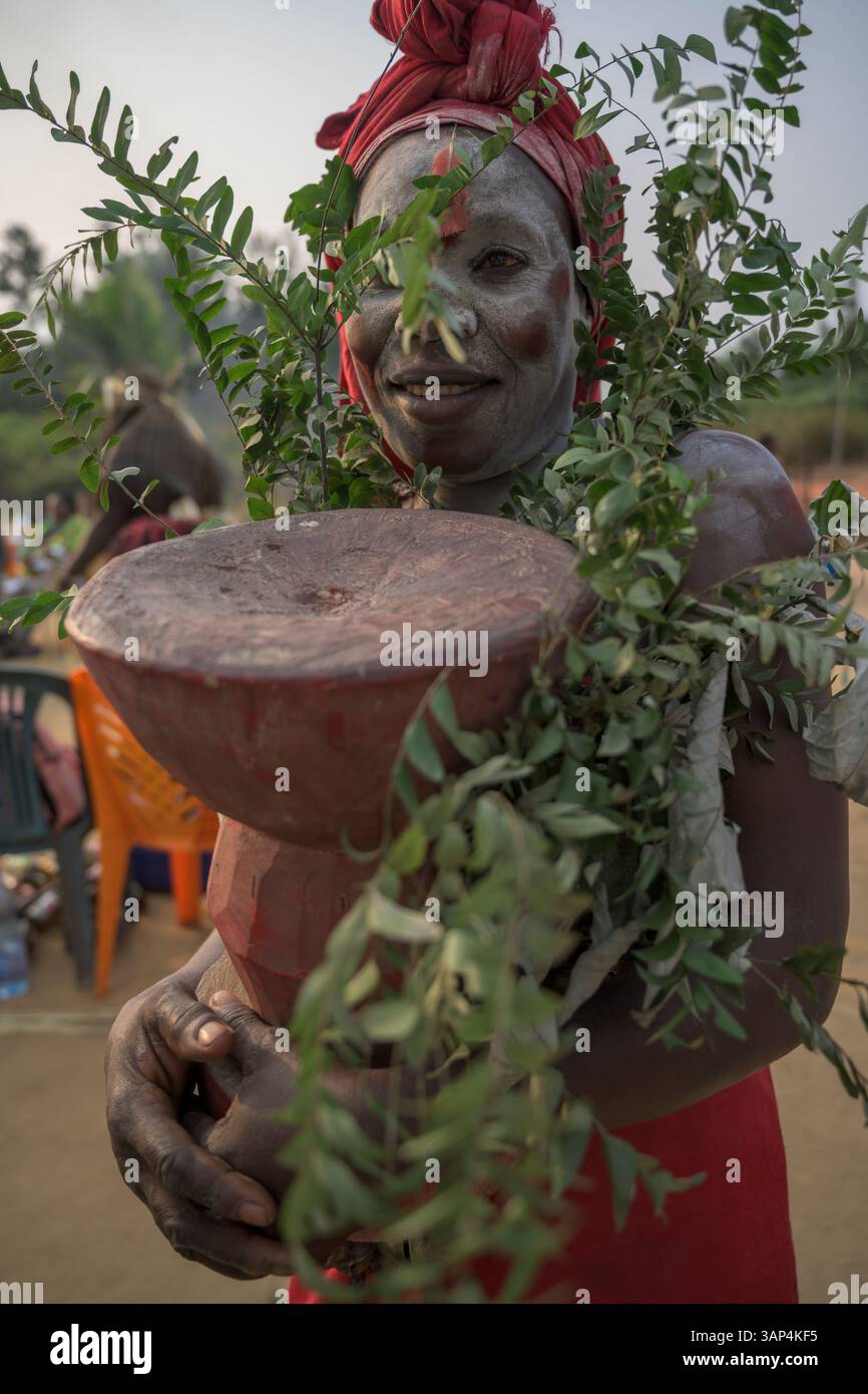 Portrait d'une femme vêtue d'une tenue rituelle et avec son visage peint, le matin devant le temple après une cérémonie de Bwiti toute la nuit. Banque D'Images