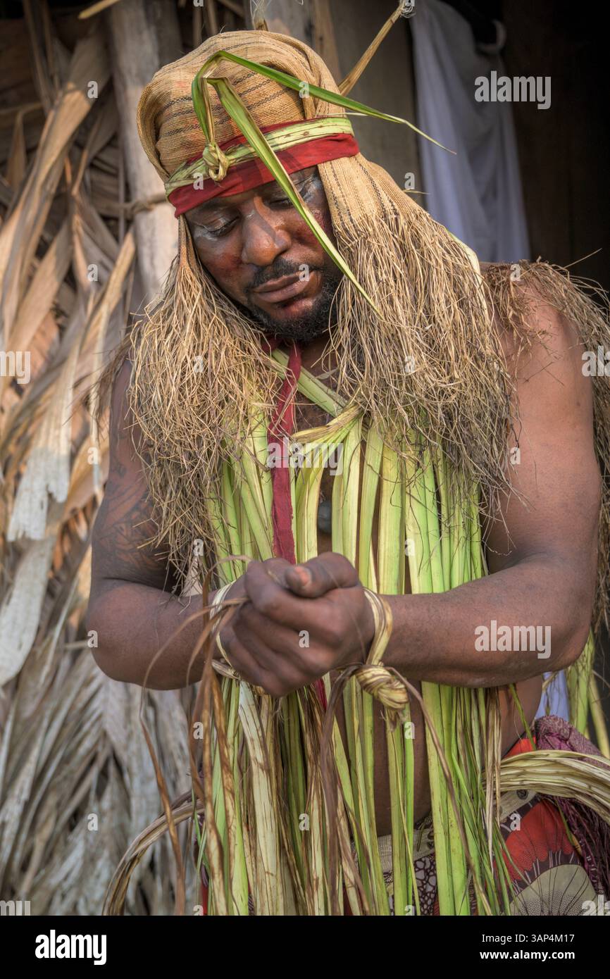 Portrait d'un homme vêtu d'un costume rituel fait de feuilles de palmier séchées, après une cérémonie de Bwiti toute la nuit. Banque D'Images