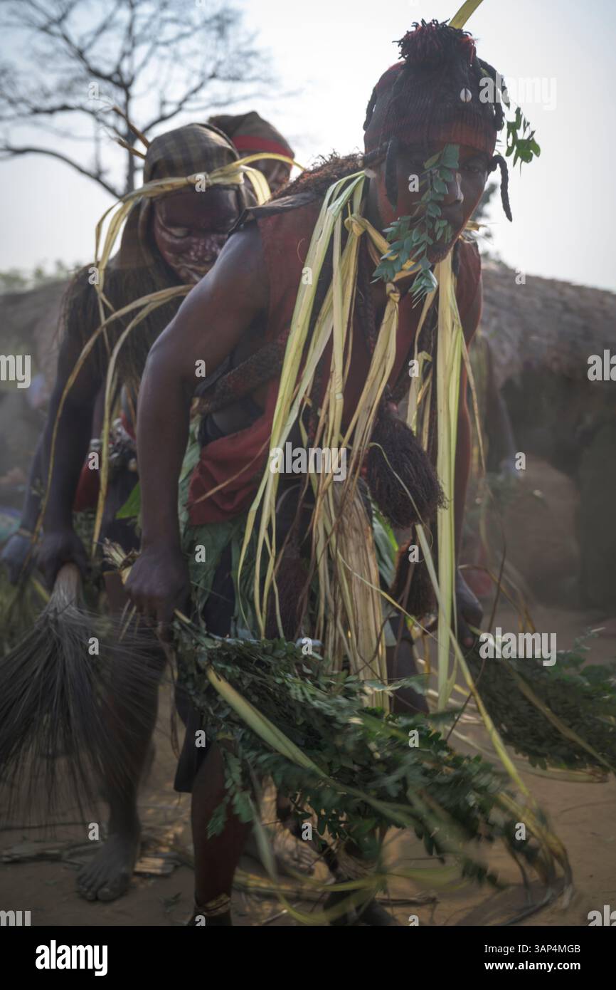 Les danseurs vêtus d'une tenue de cérémonie traditionnelle dansent devant le temple où ils ont tenu une cérémonie de Bwiti toute la nuit. Banque D'Images