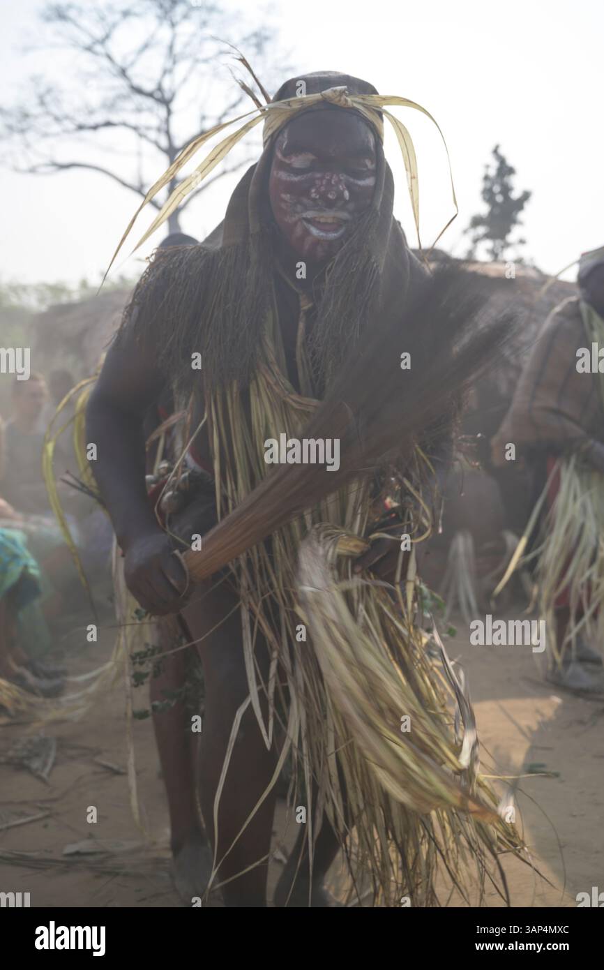 Les danseurs vêtus d'une tenue de cérémonie traditionnelle dansent devant le temple où ils ont tenu une cérémonie de Bwiti toute la nuit. Banque D'Images
