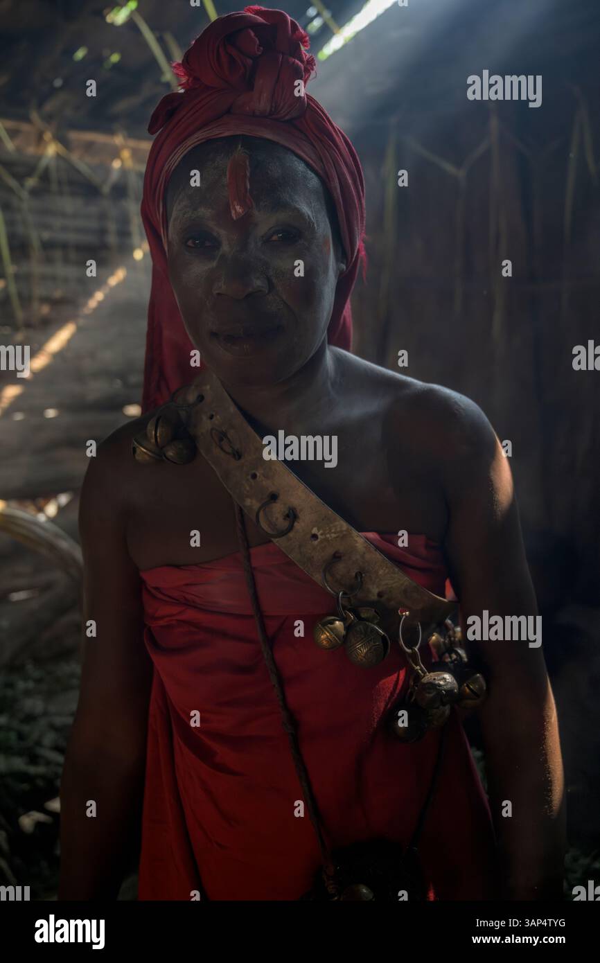 Portrait d'une femme vêtue d'une tenue rituelle et avec son visage peint, à l'intérieur du temple après une cérémonie de Bwiti toute la nuit. Banque D'Images