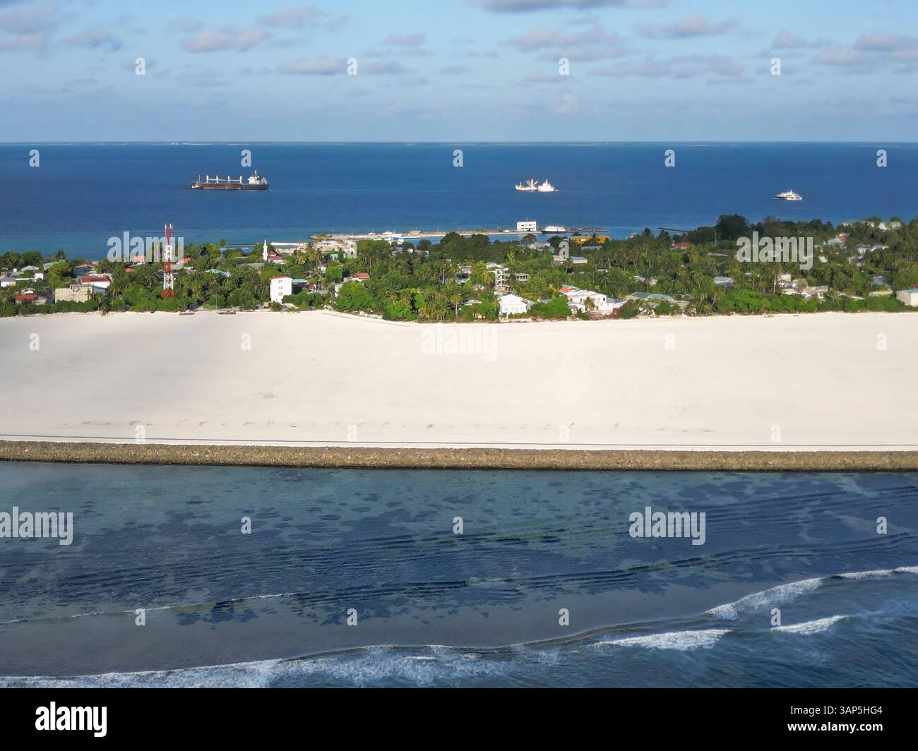 Vue aérienne de la belle plage tropicale avec des palmiers et des navires dans l'océan, Maradhoo, Maldives. Banque D'Images