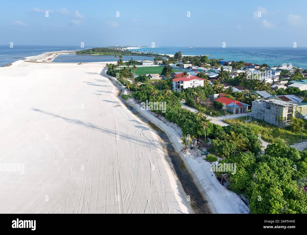 Vue aérienne de la belle plage tropicale avec des palmiers et des maisons, Maradhoo, Maldives. Banque D'Images