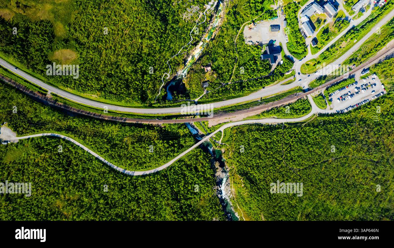 Vue aérienne du canyon pittoresque avec des voies ferrées et des voitures le long de la luxuriante rivière Abiskojakka, parc national Abisko, Suède. Banque D'Images