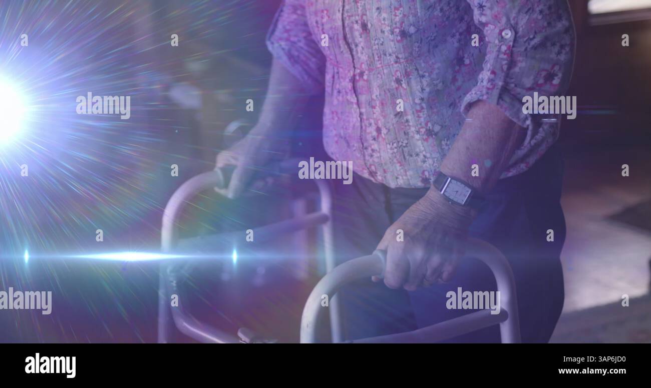 Image de la lumière se déplaçant sur la section médiane d'une femme âgée utilisant le cadre de marche Banque D'Images