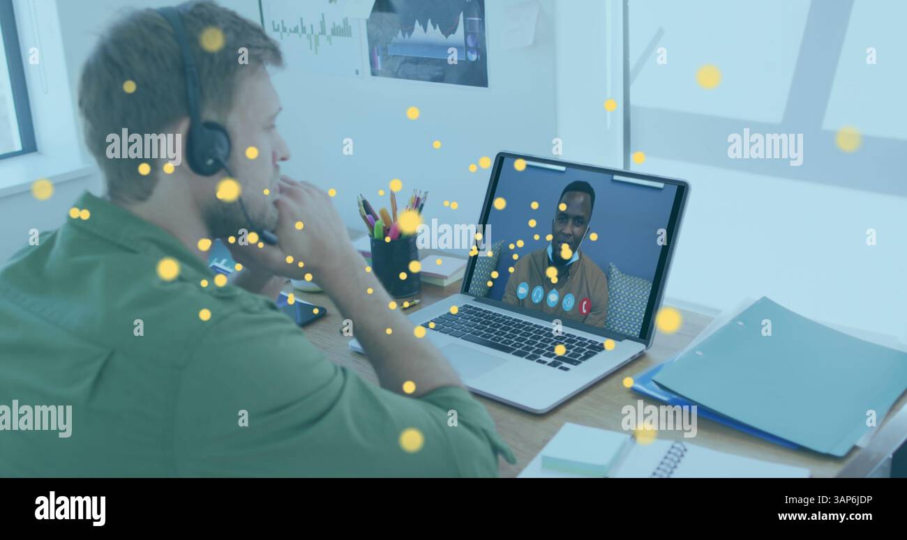 Image d'icônes bitcoin sur l'homme caucasien utilisant un casque de téléphone et un ordinateur portable Banque D'Images