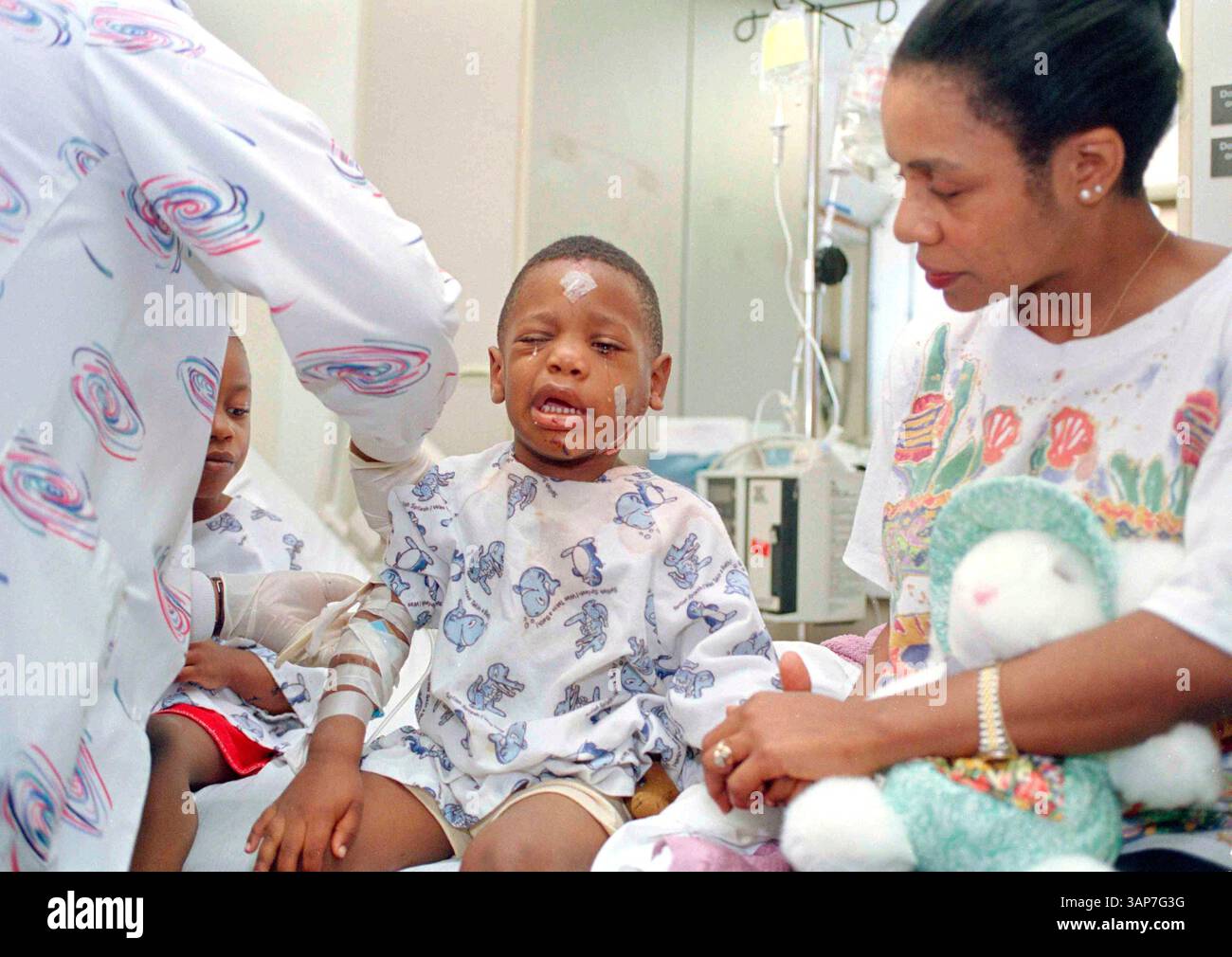 FILE - Davetta Green comforts her son, James Green, as a nurse removes an I.V. at Presbyterian Hospital in Oklahoma City on April 20, 1995. James was injured when he and his mother were in the YMCA building across the street from the Alfred P. Murrah Federal Building when it was bombed. (AP Photo, File) Banque D'Images