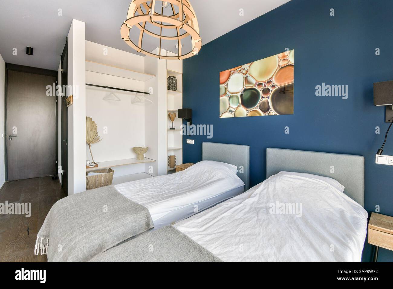 Chambre contemporaine avec lits jumeaux, décoration élégante et belle décoration murale. La chambre allie confort et esthétique moderne. Banque D'Images