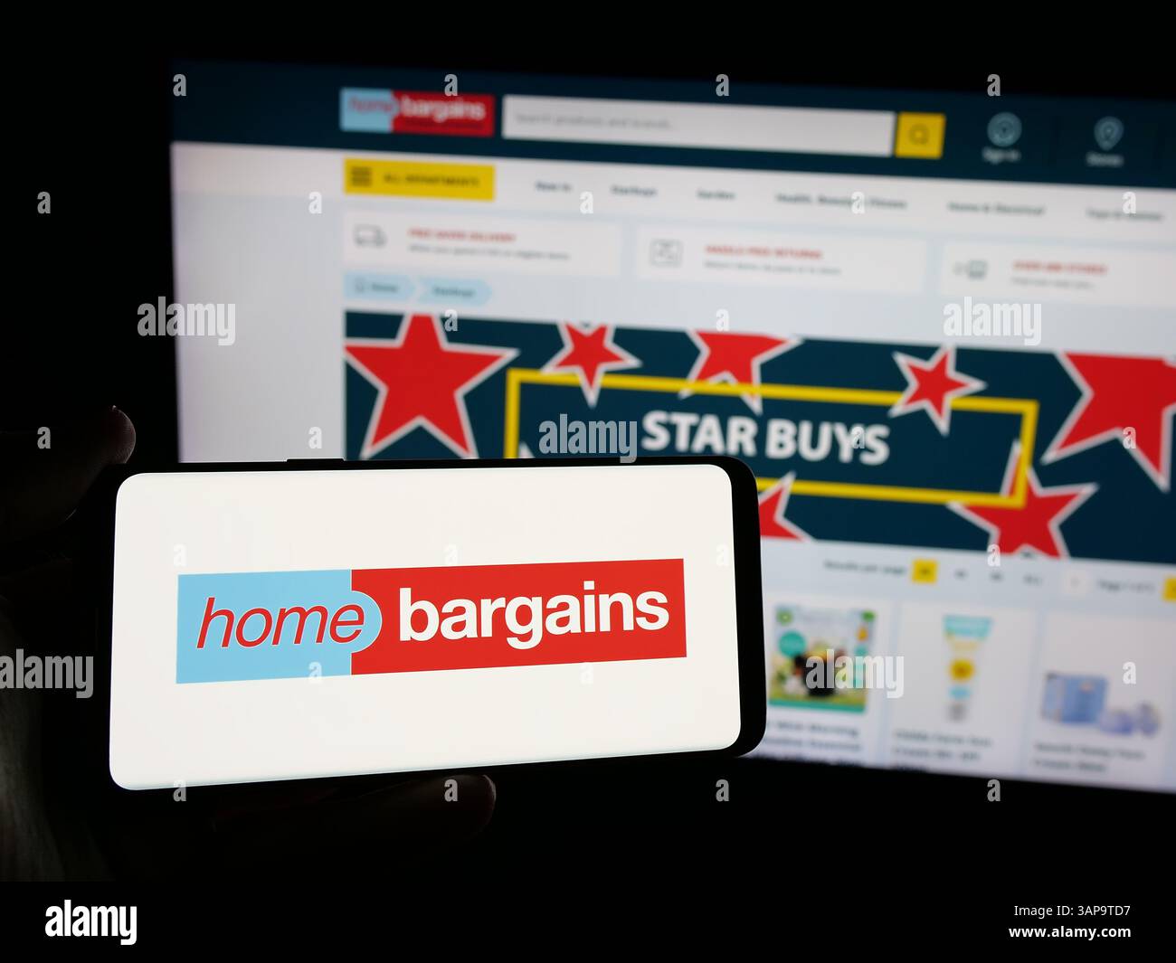 5 mars 2025, Allemagne : dans cette illustration photo, une personne tient un smartphone avec le logo de la société britannique T.J. Morris Limited (Home Bargains) sur l'écran devant le site Web de l'entreprise. (Crédit image : © timon Schneider/SOPA images via ZUMA Press Wire) USAGE ÉDITORIAL SEULEMENT ! Non destiné à UN USAGE commercial ! Banque D'Images