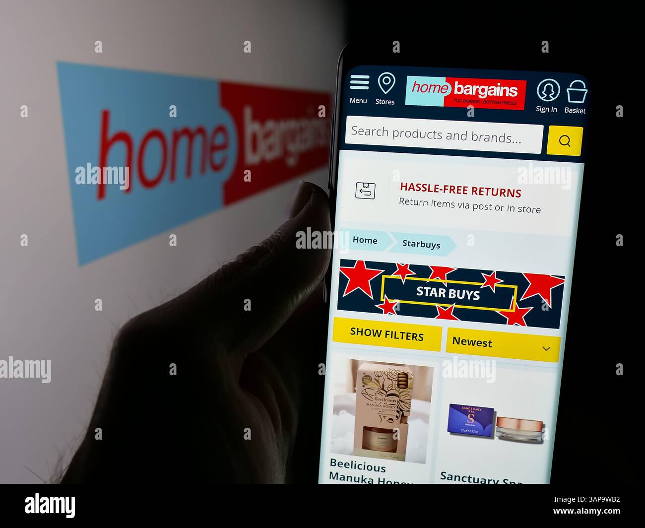 Allemagne. 5 mars 2025. Dans cette illustration photo, une personne tient un smartphone avec le site Web de la société britannique T.J. Morris Limited (Home Bargains) sur l'écran devant le logo. (Crédit image : © timon Schneider/SOPA images via ZUMA Press Wire) USAGE ÉDITORIAL SEULEMENT ! Non destiné à UN USAGE commercial ! Banque D'Images