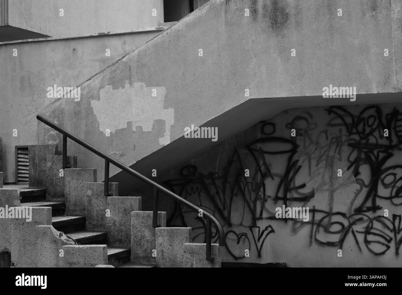 Image en noir et blanc d'escaliers qui montent d'un garage de stationnement dans le centre de Targu Mures, Roumanie. Le graffiti est écrit sur les murs. Banque D'Images