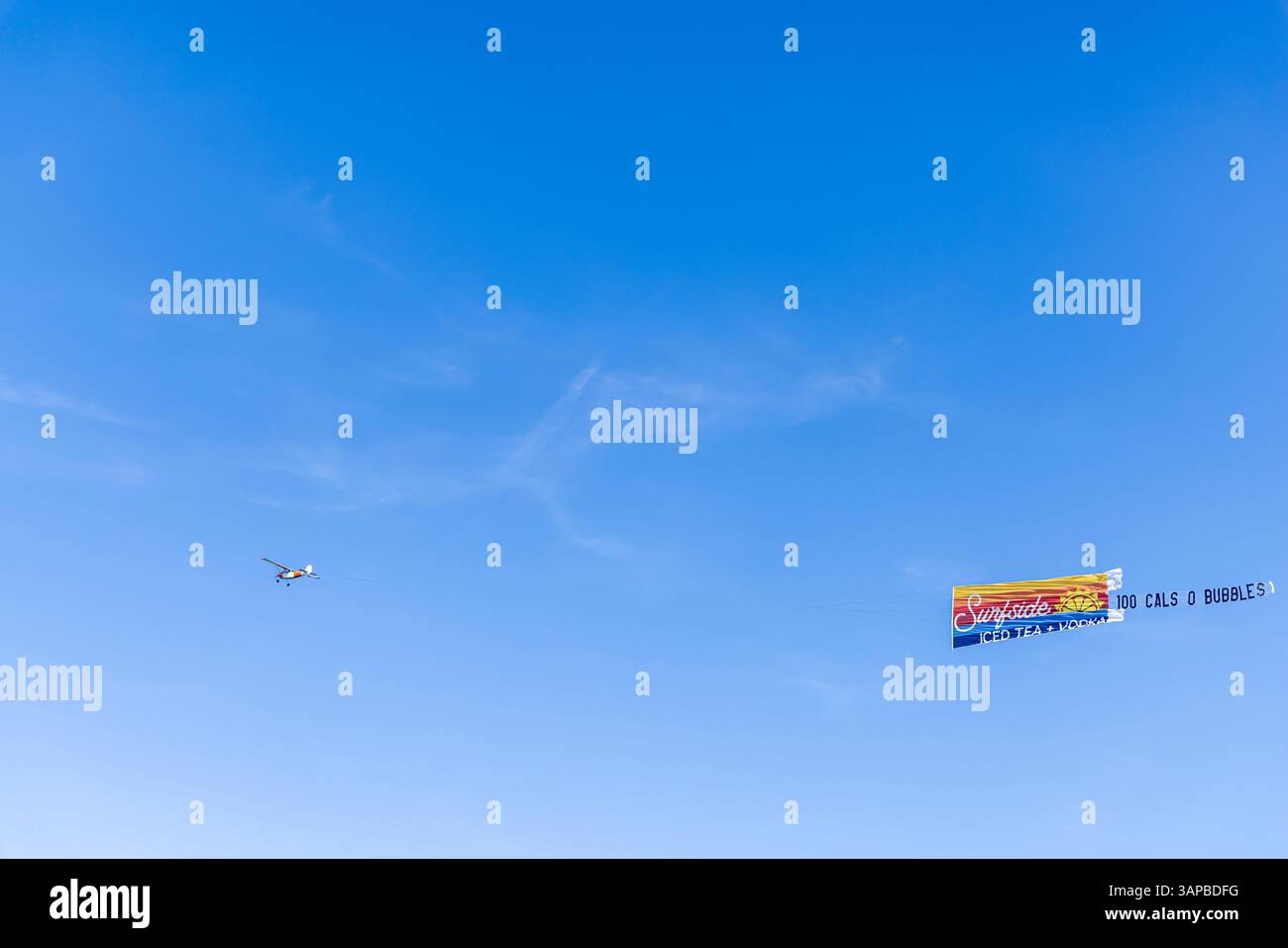 petit avion monomoteur tirant une bannière colorée pour le thé glacé surfside Banque D'Images