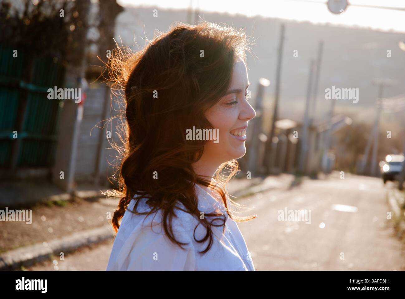 Promenade sereine en plein air avec femme souriante dans la lumière du soleil du matin. Banque D'Images