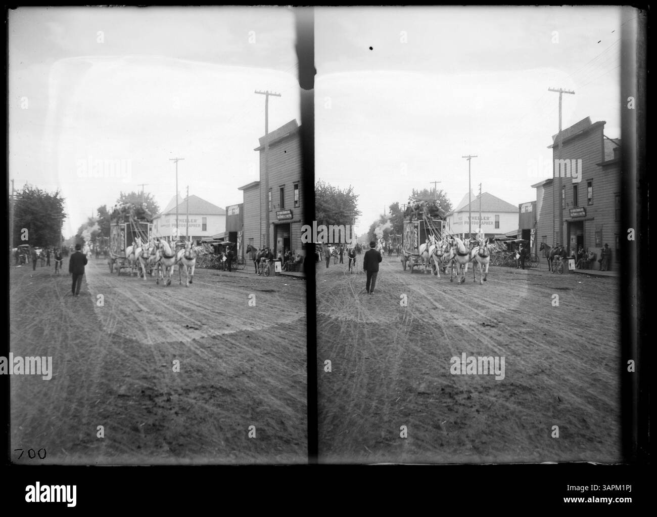 Une photographie stéréo capturant un défilé de carnaval à l'intersection des rues Alta et main à Pendleton. Éléphants, chariots, calliopes à vapeur et chameaux sont présents dans la scène animée, offrant un aperçu de la culture du divertissement passée. Banque D'Images