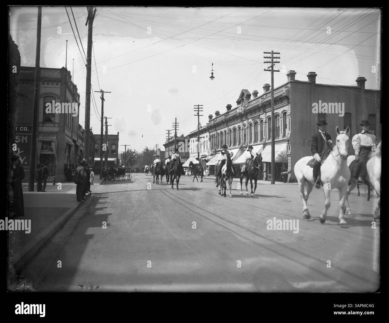 Photographie de Lee Moorhouse montrant une parade de chevaux dans la rue main à Pendleton. L'image capture l'excitation de la parade, avec des cavaliers présentant leurs chevaux lors d'un événement public. Banque D'Images