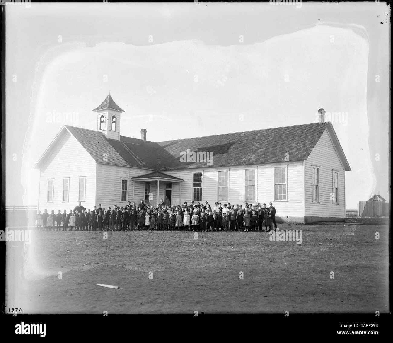 Cette photographie de Lee Moorhouse représente une école à Adams, Oregon, montrant diverses classes en groupes avec leurs professeurs, ainsi qu'une équipe de baseball de l'école. L'image reflète la vie scolaire du début du XXe siècle. Banque D'Images