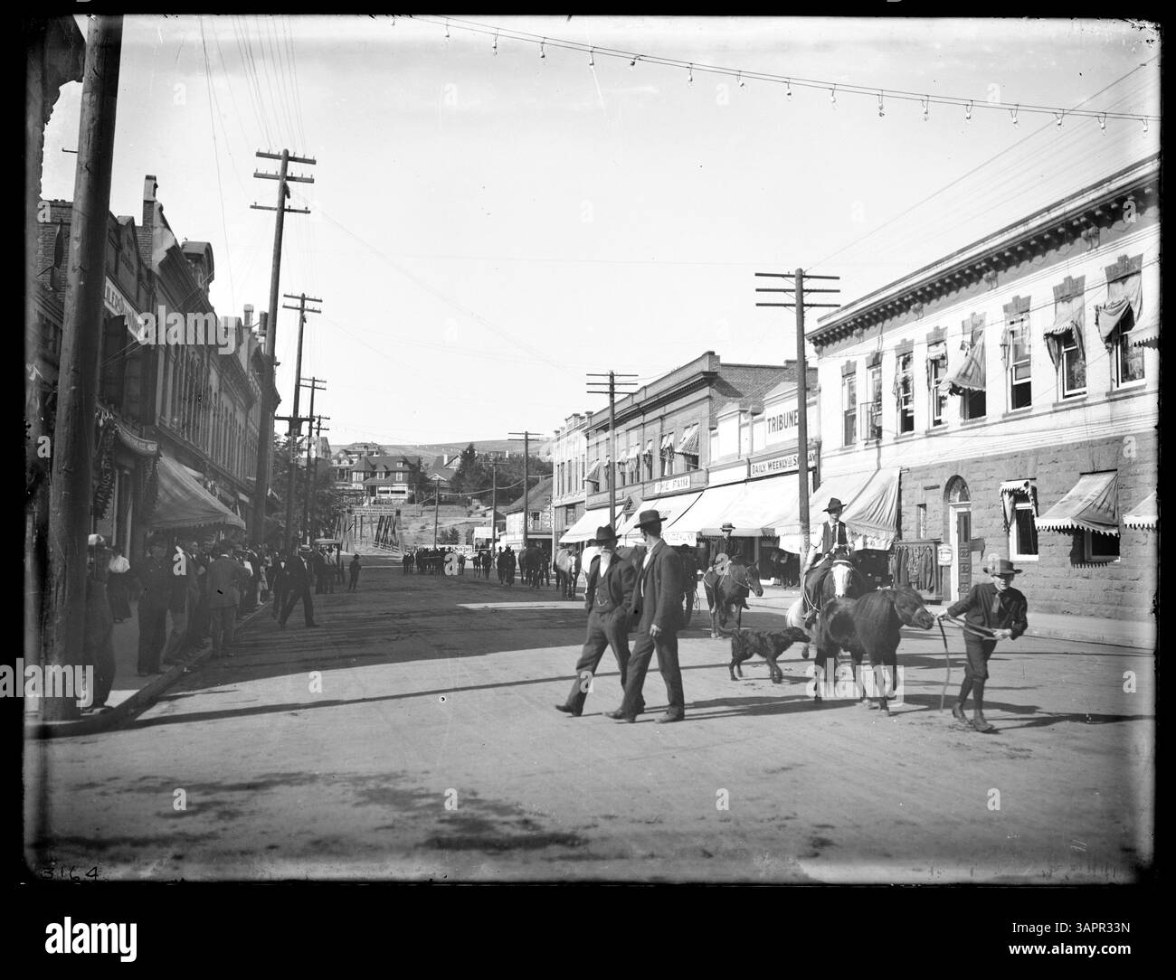 Cette photographie de Lee Moorhouse capture une parade de chevaux sur main Street à Pendleton, Oregon, mettant en valeur les festivités locales et la vie communautaire du début du XXe siècle. Banque D'Images