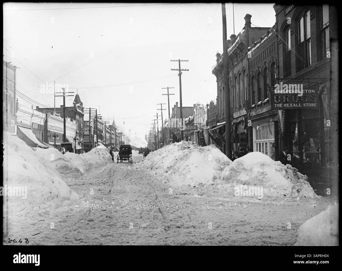 Cette photographie du 5 décembre 1916 montre de la neige profonde sur main Street à Pendleton, Oregon, avec des bâtiments comme People's Warehouse, Alexander's Department Store et The Hub visibles. Il fournit un aperçu historique de Pendleton pendant l'hiver. Banque D'Images