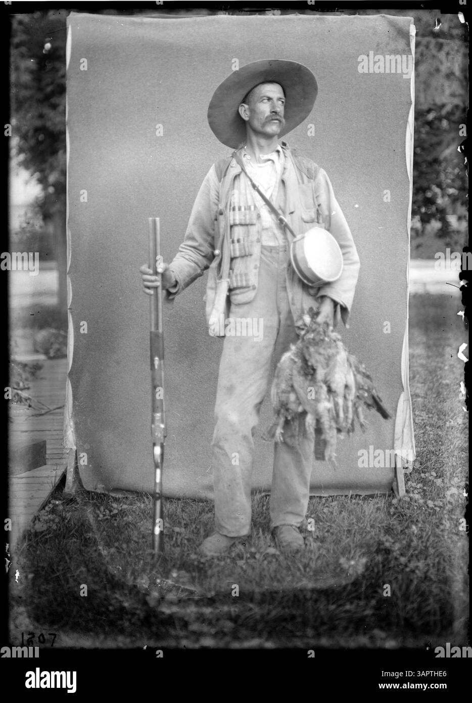 Cette image montre un chasseur avec une caille, capturant un moment de la culture de chasse du début du XXe siècle. Banque D'Images
