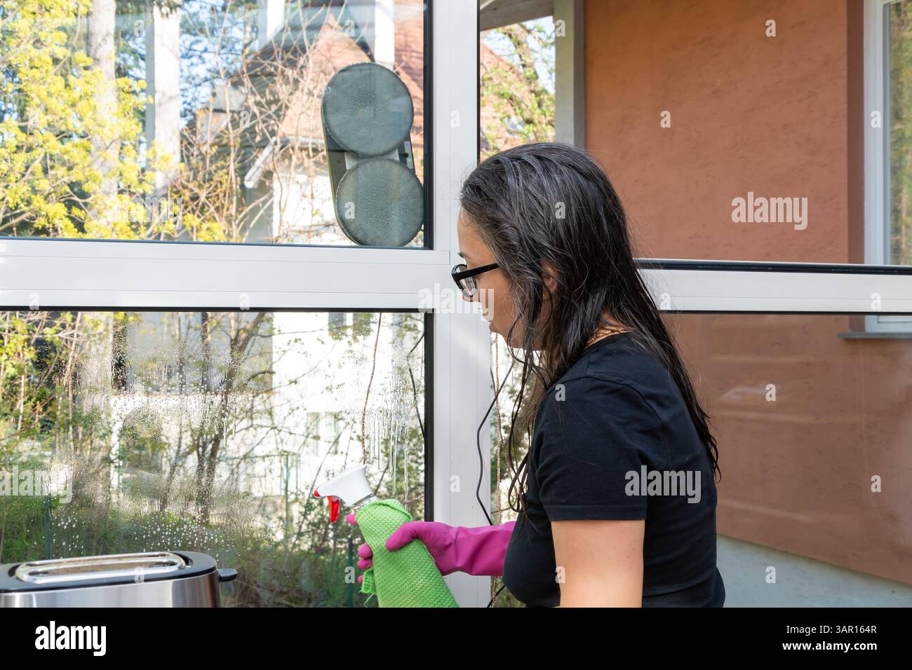 Un robot de nettoyage de vitres et une femme en cours de nettoyage Banque D'Images