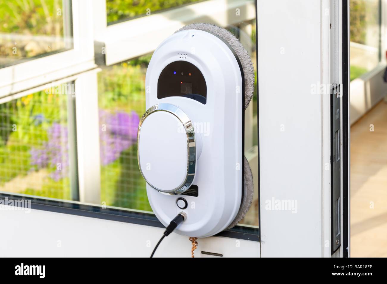 Le gadget de nettoyage intelligent des vitres est fixé au verre et nettoie automatiquement la surface Banque D'Images