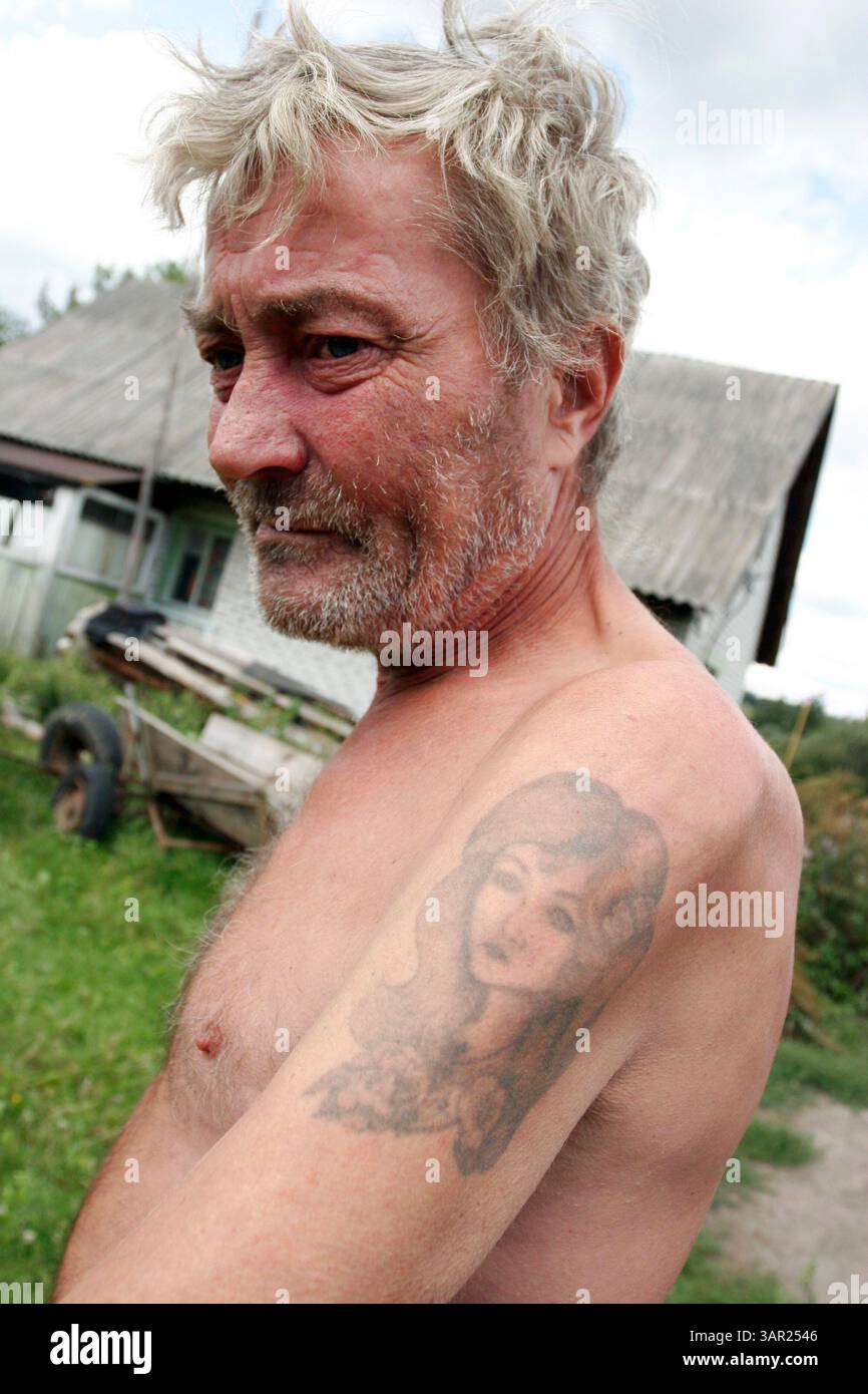 27 août 2007 - Ivankiv, Ukraine - 'je suis né ici et je vais mourir ici. Je veux déjà mourir. Pardonnez-moi, je suis ivre. Je bois beaucoup maintenant. Nous n'avons que ce que Dieu nous donne, notre santé, notre place, nos amis', VASILY KOZACHENKO, agriculteur. Après la mort de sa femme Natasha en janvier 2007, Kozachenko a tatoué son visage sur son épaule comme un mémorial personnel. Elle meurt d'un cancer du foie après une longue maladie, quelques jours après son 46e anniversaire. Il vivait alors seul, cultivant une petite parcelle de terre à la périphérie d'Ivankiv, la ville habitée la plus proche de Tchernobyl. Avant l'accident, Vasily et sa famille vivaient Banque D'Images
