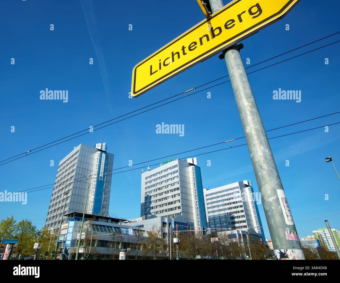 Vue de l'ancien City Hotel Berlin East, aujourd'hui logement de réfugiés, derrière le panneau du quartier Lichtenberg à Berlin, en Allemagne. Banque D'Images