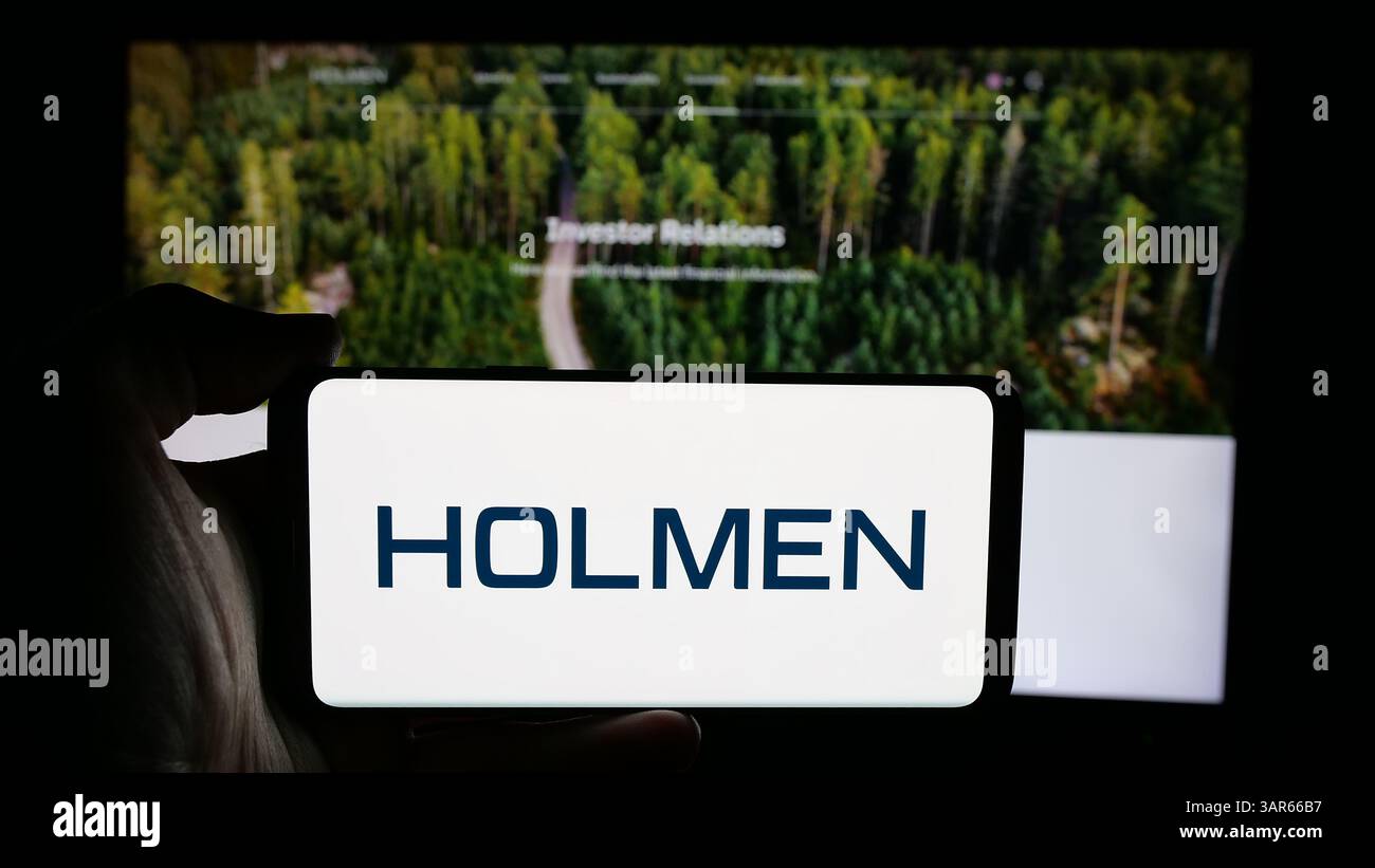 Allemagne. 12 mars 2025. Dans cette illustration photo, une personne tient un téléphone portable avec le logo de la société forestière suédoise Holmen AB sur l'écran en face de la page Web. (Crédit image : © timon Schneider/SOPA images via ZUMA Press Wire) USAGE ÉDITORIAL SEULEMENT ! Non destiné à UN USAGE commercial ! Banque D'Images