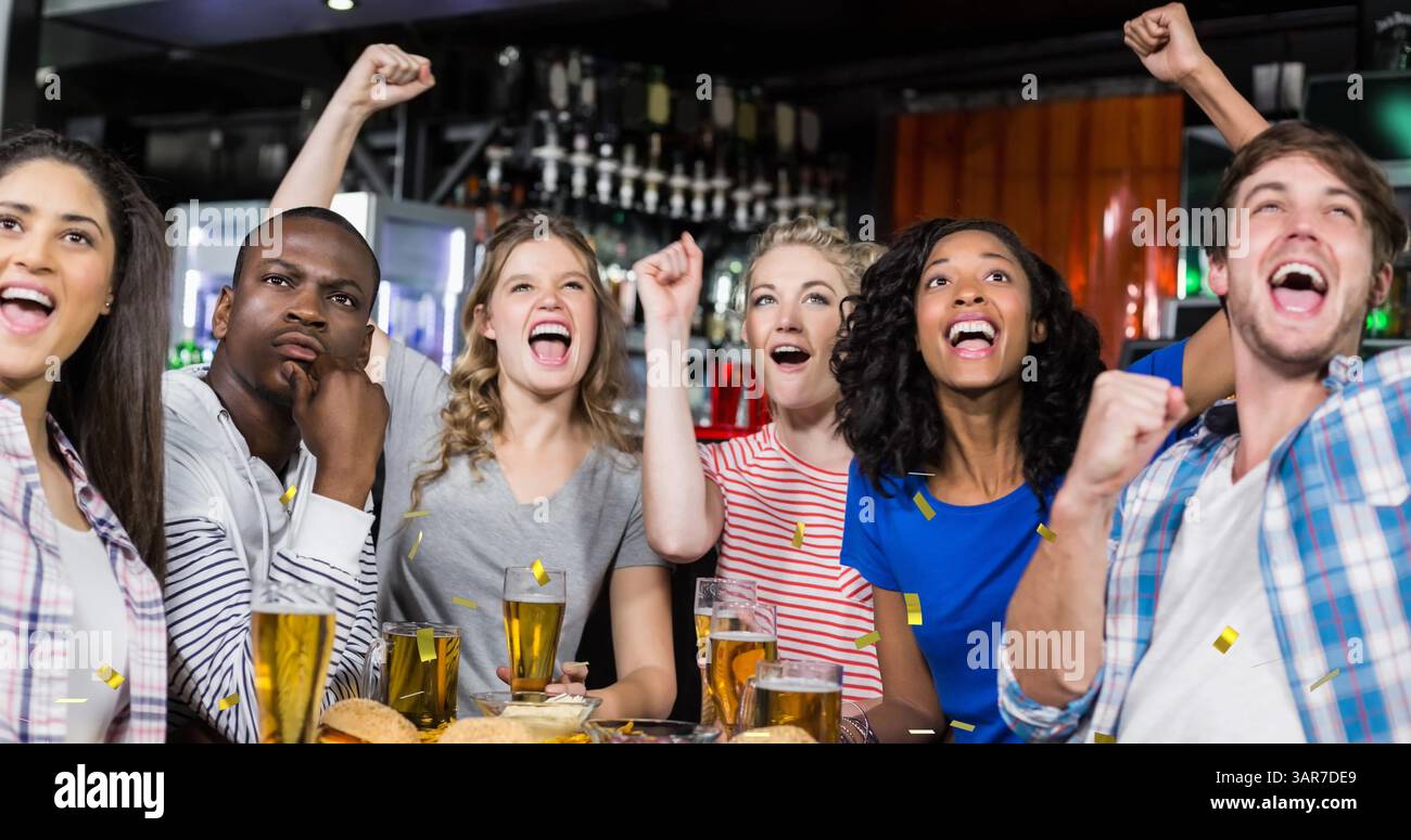 Image de confettis en or tombant sur un groupe heureux et diversifié d'amis buvant dans le bar Banque D'Images