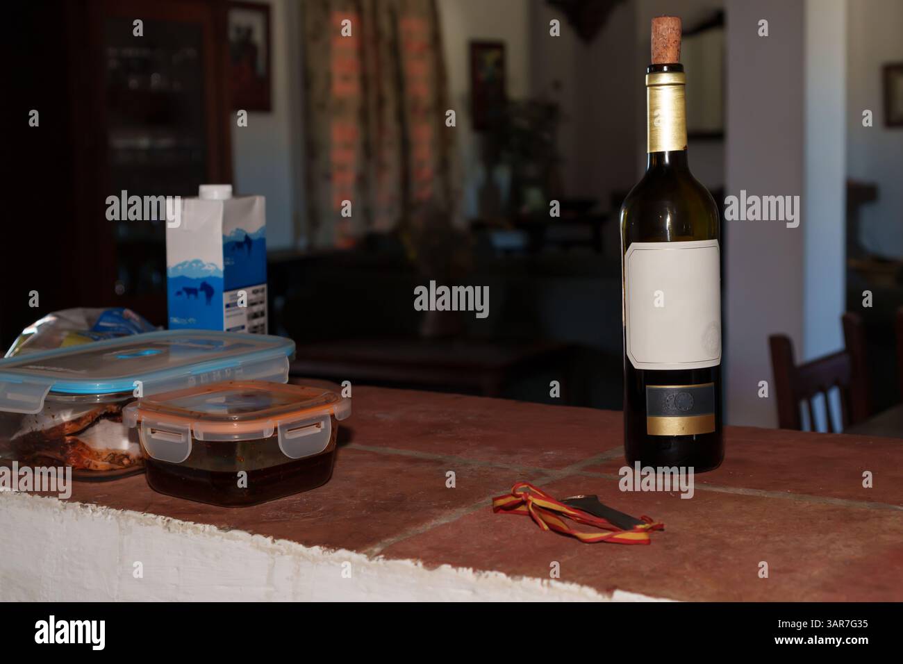 Bouteille de vin avec une étiquette vierge se tient sur un comptoir de cuisine rustique à côté des restes et une médaille Banque D'Images