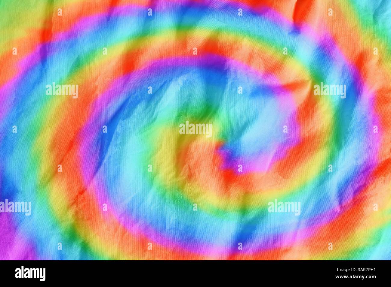 Tissu brillant teint avec la technique de tie-dye. Textile avec des tourbillons dans des couleurs arc-en-ciel Banque D'Images